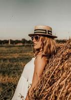 une fille avec un chapeau de paille se pencha en arrière. une fille bronzée se repose dans le sud. vacances d'été en europe. photo