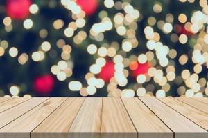 dessus de table en bois vide avec arbre de noël flou avec fond clair bokeh photo