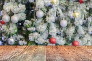 dessus de table en bois vide avec arbre de noël flou avec fond clair bokeh photo