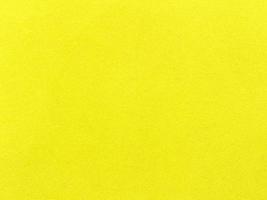 texture de tissu de velours jaune utilisée comme arrière-plan. fond de tissu jaune vide de matière textile douce et lisse. il y a de l'espace pour le texte. photo