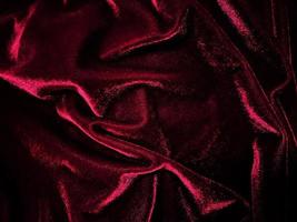 texture de tissu de velours rouge utilisée comme arrière-plan. fond de tissu rouge vide de matière textile douce et lisse. il y a de l'espace pour le texte. photo