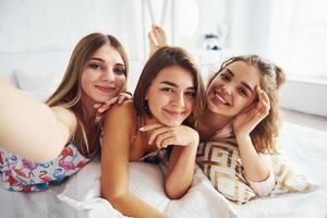 faire des selfies. heureux amis féminins ayant du bon temps à la soirée pyjama dans la chambre photo