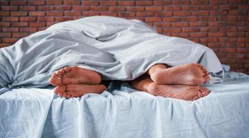 vue rapprochée des pieds du couple qui dort ensemble dans la chambre le matin photo