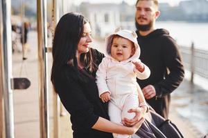 une famille joyeuse se promène avec son enfant dans le parc photo