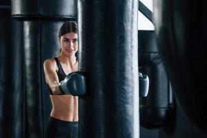 jeune femme en tenue de sport est dans la salle de gym ayant une journée d'exercice. conception de la boxe photo