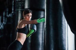 jeune femme en tenue de sport est dans la salle de gym ayant une journée d'exercice. conception de la boxe photo