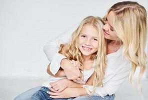 proximité des gens. mère avec sa fille ensemble dans le studio avec un fond blanc photo