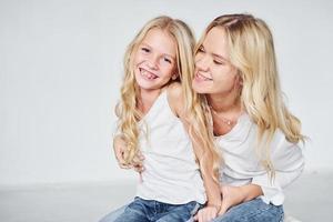 proximité des gens. mère avec sa fille ensemble dans le studio avec un fond blanc photo