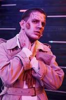 portrait d'homme qui participe à la fête d'halloween thématique en maquillage et costume de zombie photo