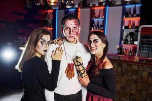 les amis sont à la fête d'halloween thématique avec un maquillage et des costumes effrayants photo