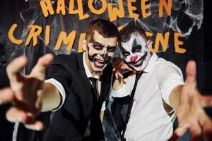 des amis sont à la fête d'halloween thématique avec un maquillage effrayant et des costumes criant à la caméra photo