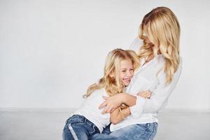 mère avec sa fille ensemble dans le studio avec un fond blanc photo