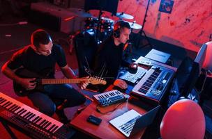 l'ingénieur du son a une session d'enregistrement avec le guitariste à l'intérieur du studio photo