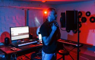 le chanteur a une session d'enregistrement à l'intérieur dans le studio professionnel moderne photo