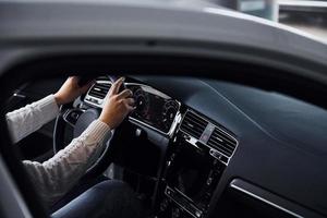 vue particulaire de l'homme en tenue de soirée qui roule sur une voiture neuve photo