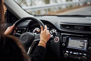 vue arrière de la conductrice brune qui conduit une voiture moderne pendant la journée photo