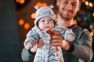 père avec son enfant ensemble dans une chambre décorée de noël photo