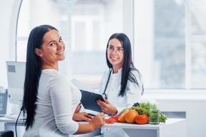 une nutritionniste donne une consultation au patient à l'intérieur du bureau photo