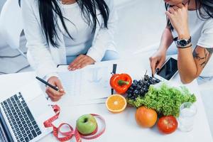 vue de dessus d'une nutritionniste féminine qui donne des consultations au patient à l'intérieur du bureau photo