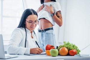 une nutritionniste donne une consultation au patient à l'intérieur du bureau photo