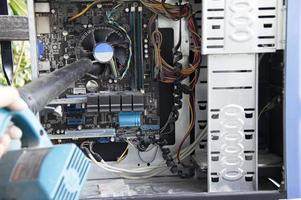 photographie d'un technicien soufflant la poussière d'un ordinateur photo