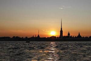 à la silhouette de la forteresse pierre et paul au coucher du soleil, vue depuis la rivière neva photo