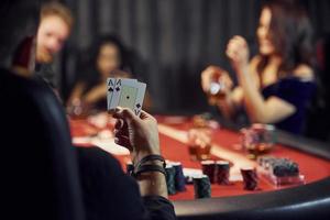 le gars a une paire d'as. groupe de jeunes élégants qui jouent au poker au casino ensemble photo