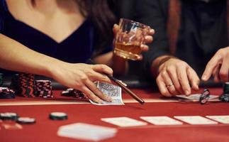 vue rapprochée des mains des jeunes élégants qui jouent au poker au casino photo