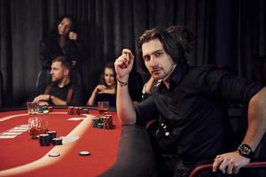 groupe de jeunes élégants qui jouent au poker au casino ensemble photo