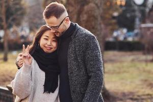 heureux couple multiracial ensemble à l'extérieur de la ville. fille asiatique avec son petit ami caucasien photo