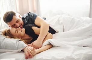 mignon jeune couple allongé sur le lit et dormir ensemble photo