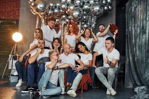 heureux jeunes célébrant le nouvel an dans une salle décorée de noël avec un équipement d'éclairage photo