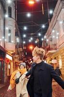 un couple se promène ensemble dans la rue décorée de noël photo