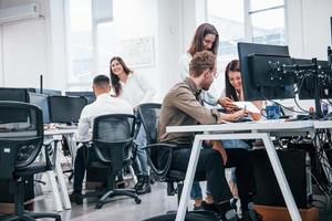 groupe de jeunes gens d'affaires qui travaillent par ordinateur dans le bureau moderne photo