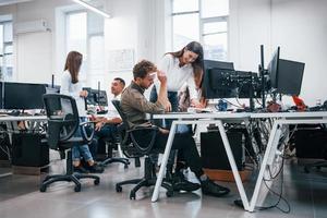 groupe de jeunes gens d'affaires qui travaillent par ordinateur dans le bureau moderne photo