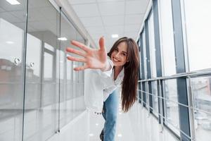 brune en chemise blanche à l'intérieur dans un aéroport moderne ou un couloir pendant la journée photo