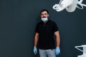 portrait de dentiste en gants qui se tient à l'intérieur de la clinique photo