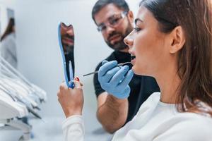 une jeune femme adulte a une visite à la clinique du dentiste. conception de la stomatologie photo