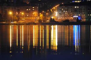 ville de nuit reflétée dans l'eau photo