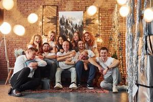 jeunes souriants célébrant le nouvel an dans une chambre confortable décorée de noël ensemble photo