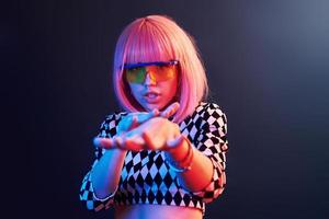 portrait de jeune fille aux cheveux blonds à lunettes en néon rouge et bleu en studio photo