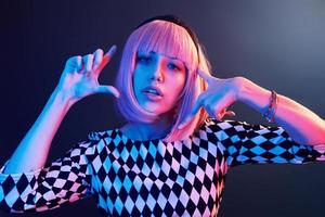 portrait de jeune fille aux cheveux blonds en néon rouge et bleu en studio photo