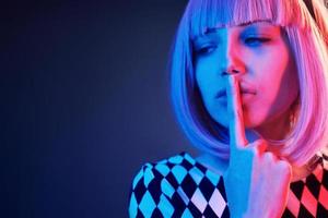 portrait de jeune fille aux cheveux blonds en néon rouge et bleu en studio photo