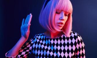 portrait de jeune fille aux cheveux blonds en néon rouge et bleu en studio photo