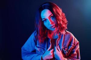 portrait de jeune fille aux cheveux bouclés en néon rouge et bleu en studio photo