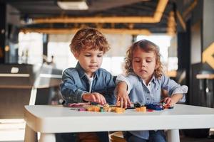 les petits amis s'amusent avec des jouets de construction dans la salle de jeux. jeux éducatifs maternelle photo