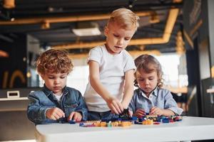 les petits amis s'amusent avec des jouets de construction dans la salle de jeux. jeux éducatifs maternelle photo