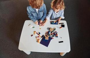 les petits amis s'amusent avec des jouets de construction dans la salle de jeux. jeux éducatifs maternelle photo