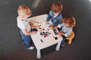 les petits amis s'amusent avec des jouets de construction dans la salle de jeux. jeux éducatifs maternelle photo