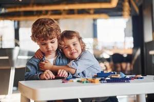 les petits amis s'amusent avec des jouets de construction dans la salle de jeux. jeux éducatifs maternelle photo